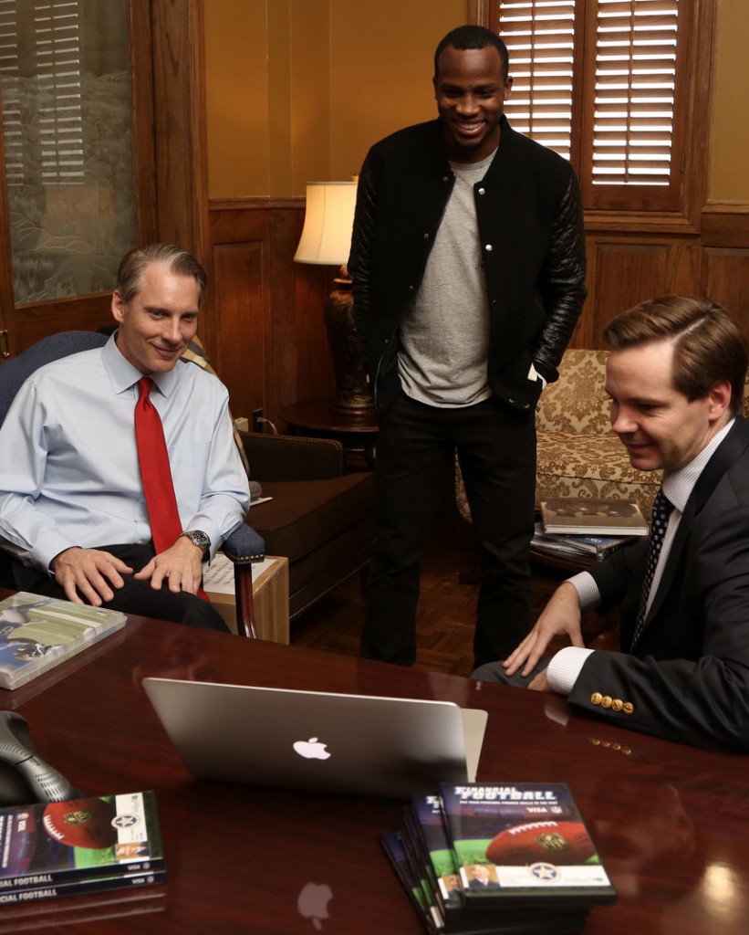 : State Treasurer Ken MIller, former OU and current NFL player Ryan Broyles, and Nat Sillin of Visa Inc. watch a demonstration of Financial Football, a video game to help student learn basic financial skills. The three announced release of the game in the State Treasurer's Office at the State Capitol on Wednesday morning. Photo by : Travis Caperton, Capitol Photographer.