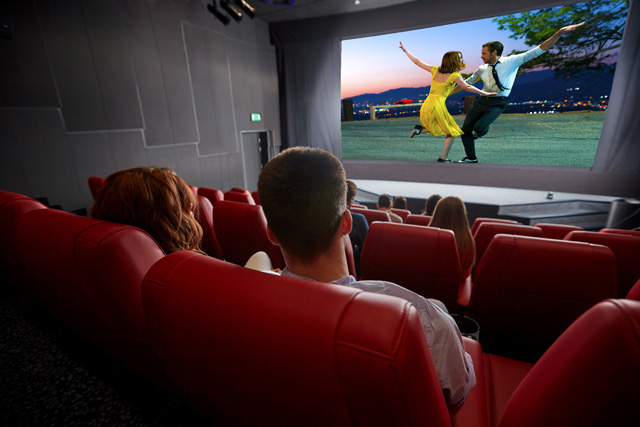 happy couple watching movie in theater or cinema