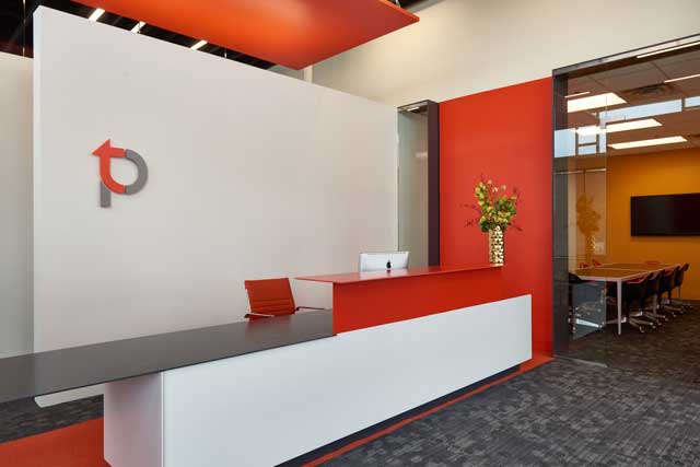 : A crisp, streamlined, modern look greets clients at TPC Studios. Different shades of warm red are among highlights in the color palette.