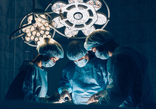 Surgeons team working with Monitoring of patient in surgical operating room. breast augmentation