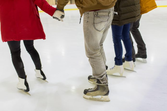 close up of friends on skating rink