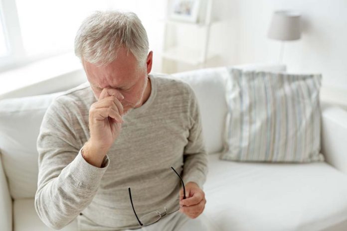 senior man suffering from headache at home