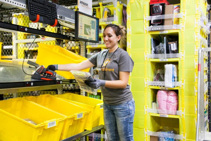 An Amazon fulfillment center employee fills orders.
