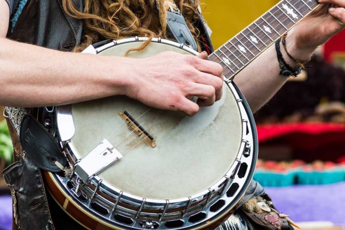 Close up of a banjo player playing music for an audience at a fa